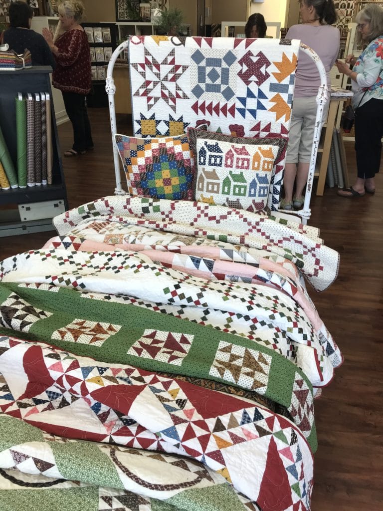 antique bed with scrappy quilts on it
