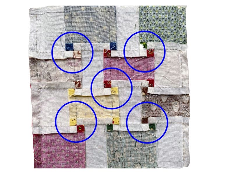 The circles are used to point out how to flatten the seams in a hand pieced 16-patch block