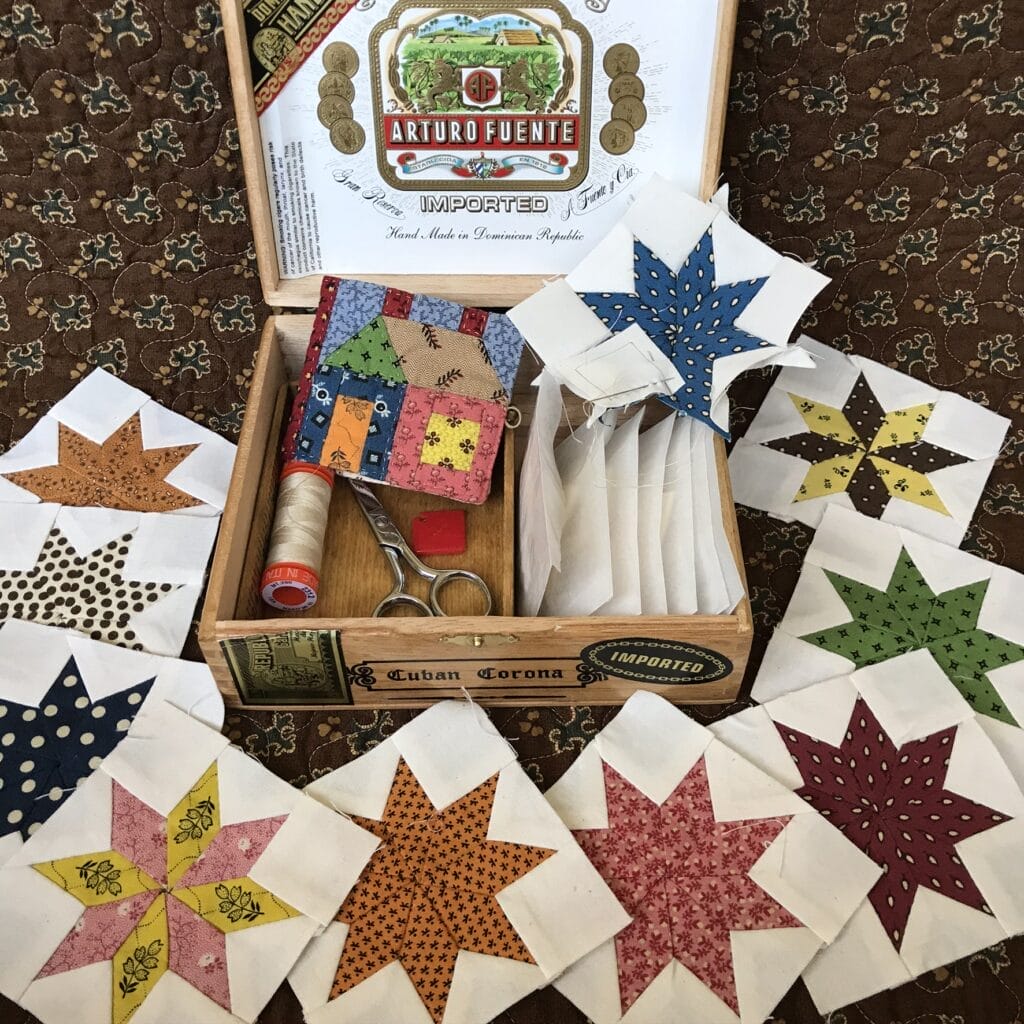 Cigar box with star quilt blocks and sewing tools