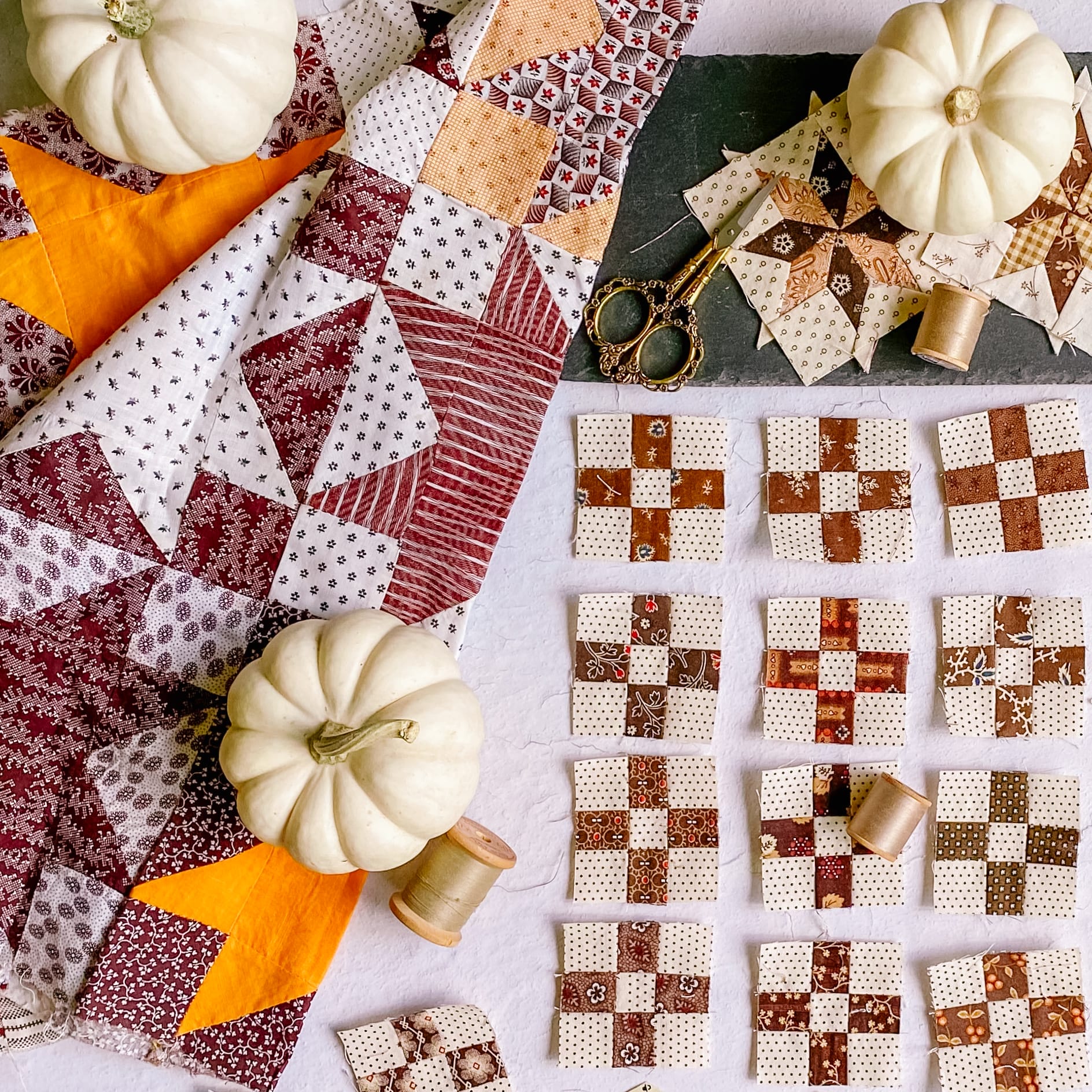 Assorted fall themed quilting fabrics, quilt top and blocks.