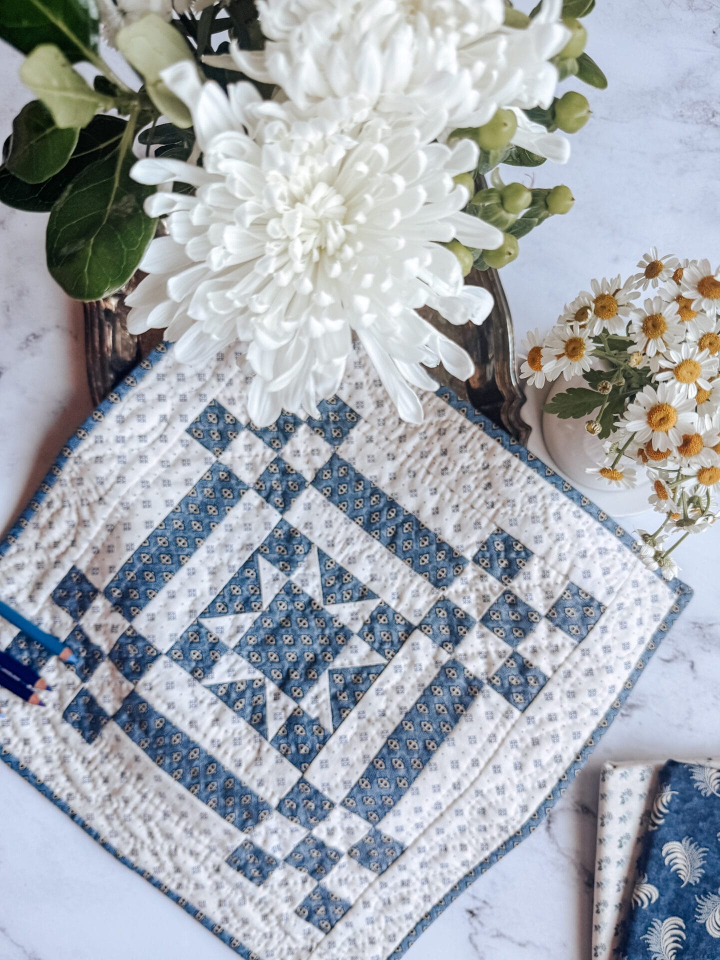 small blue and white quilt with flowers