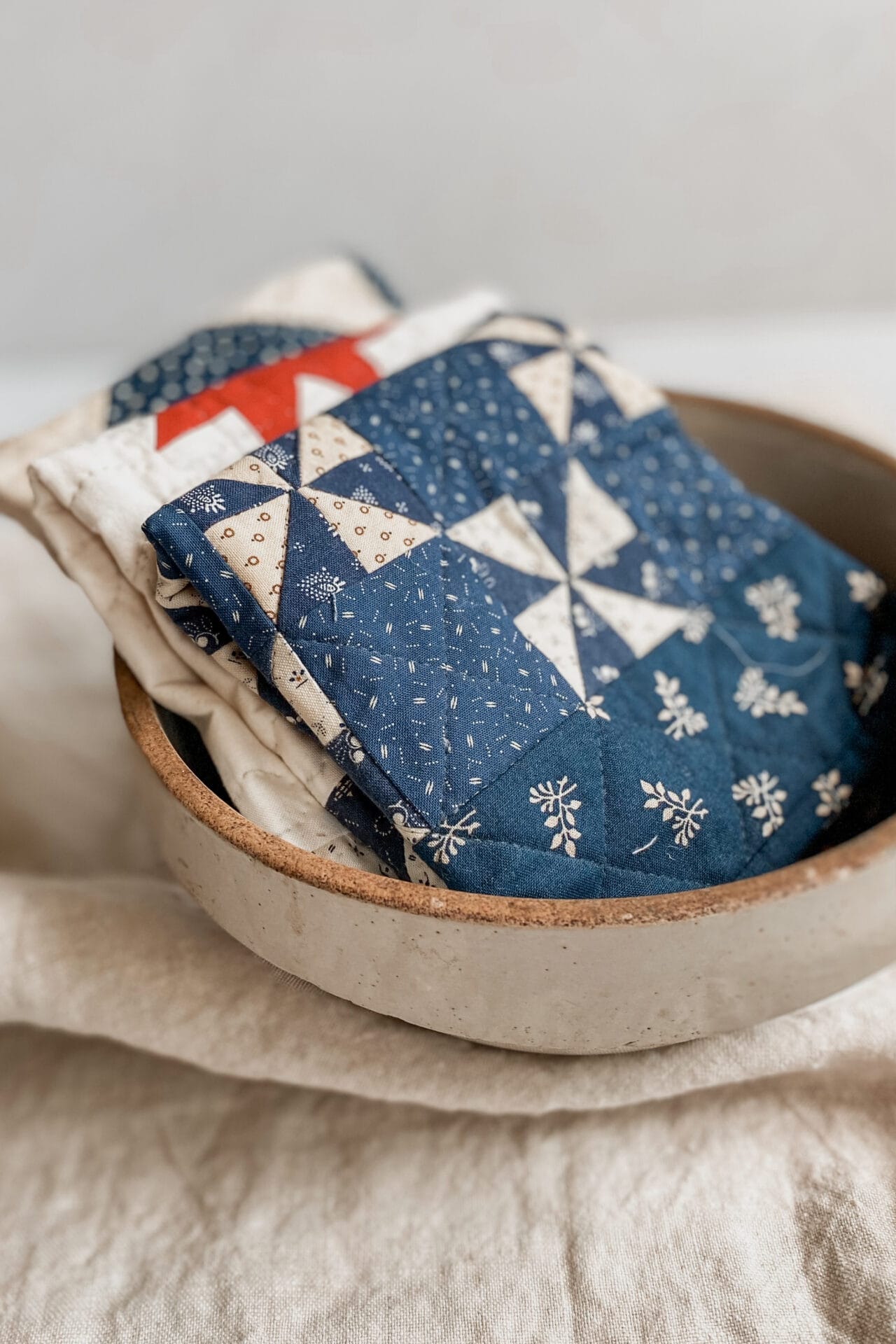 Three small quilts in a ceramic bowl